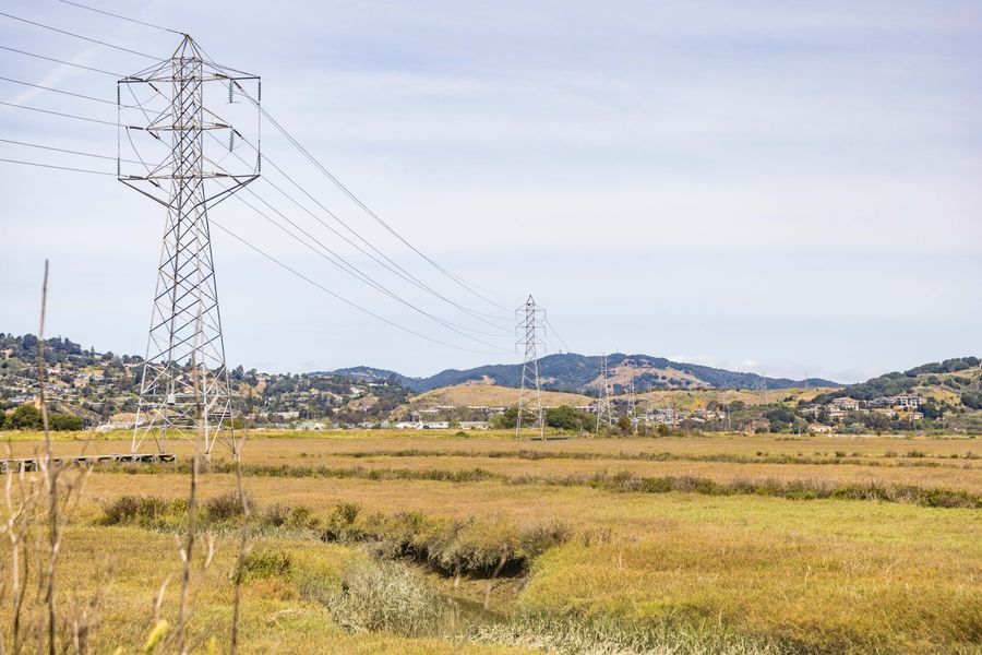 Transmission towers carrying power lines across open hill country